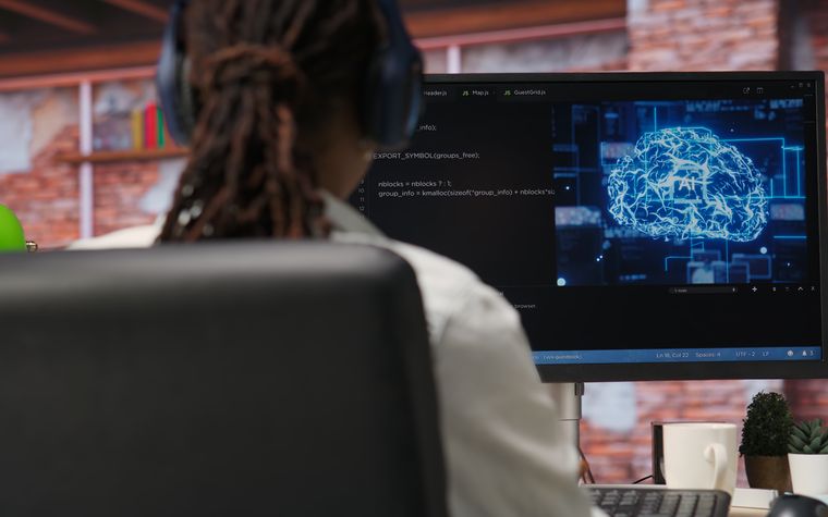 Pessoa estudando Inteligência Artificial em frente ao computador